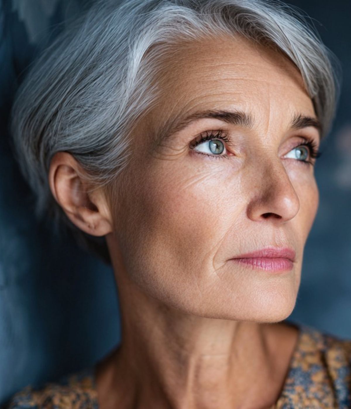 A woman with silver hair, looking ahead