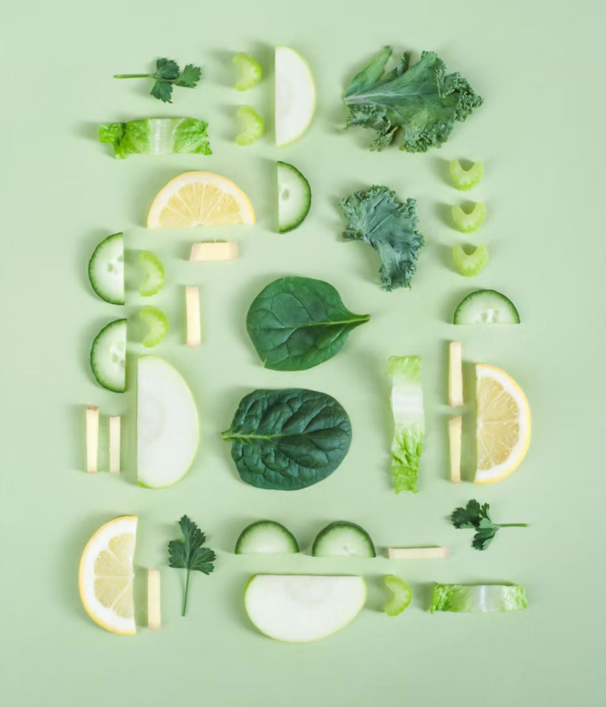 Fresh greens and vegetables arranged on a sage background